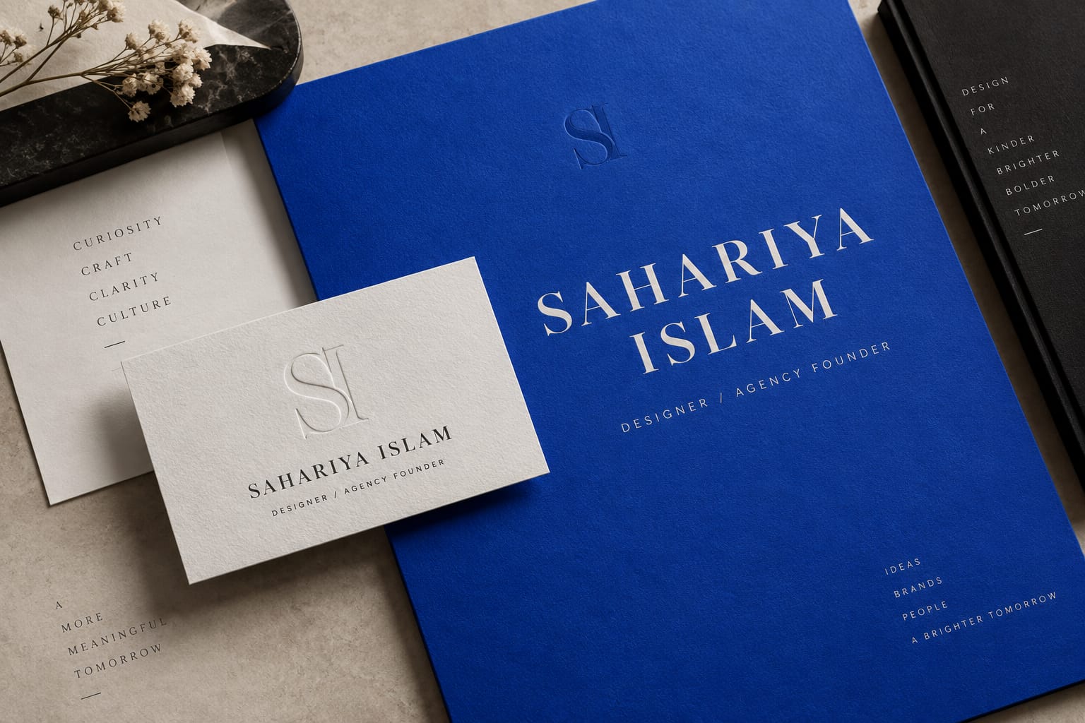 AI-generated identity exploration for Sahariya Islam: an embossed SI monogram business card and a cobalt folder